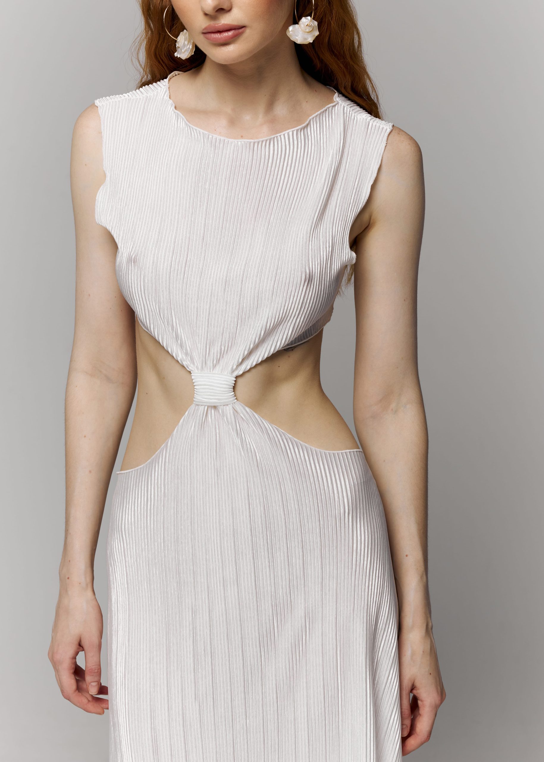 Біла сукня виконана з атласної тканини пліссе